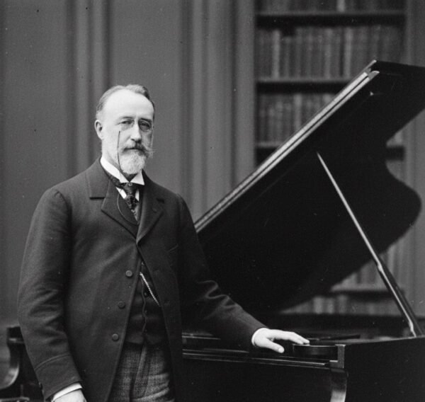 IMAGEN DE THEODORE DUBOIS PARADO JUNTO A UN PIANO